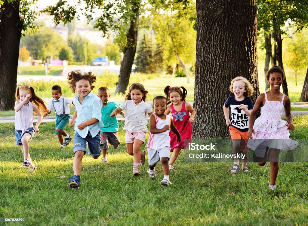 um grupo de pré-escolares correndo na grama no Parque - Foto de stock de Criança royalty-free
