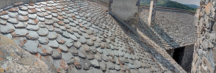 Photograph of an old stone roof roof in the sun in summer