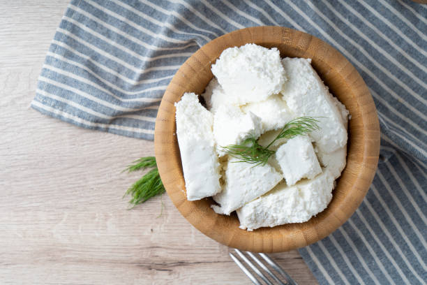 Traditional homemade salted cottage cheese cheese in a wooden bowl stock photo