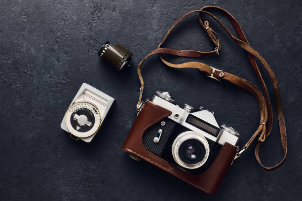 istock Old retro camera and vintage exposure meter on black background, flat lay 1367832837