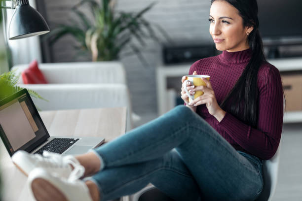 istock Beautiful woman drinking a cup of coffee while looking forward at home. 1367833145