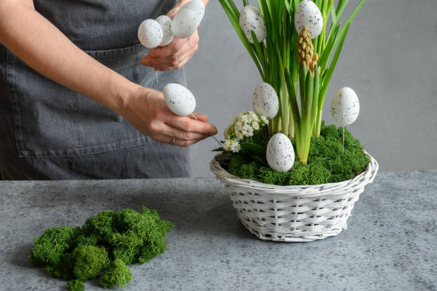 istock Woman make Easter floral composition with eggs, decorative moss and bunny. 1367833545