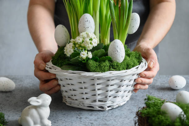 istock Easter table centerpiece with festive eggs, moss and bunny. Spring floral workshop. 1367833547