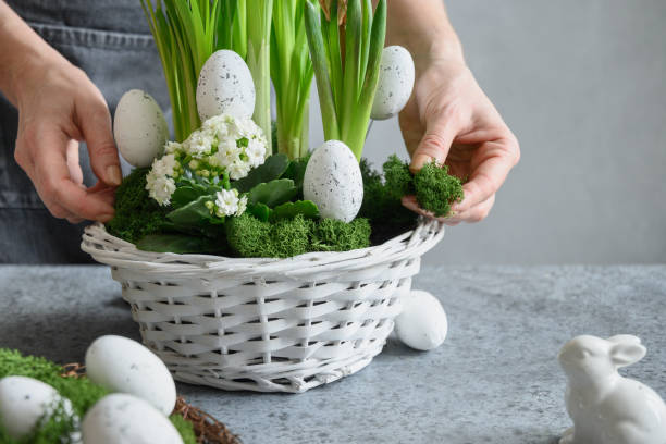 istock Woman make Easter floral composition with eggs, green moss and bunny. 1367833557