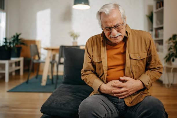 un homme âgé a mal au ventre - système digestif humain photos et images de collection