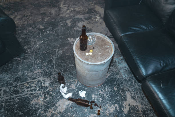 istock A poverty or criminal interior with black couch and empty beer bottles on a barrel in front of it 1367834697