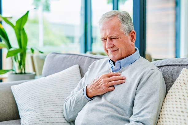 Shot of a senior man holding his chest in pain at a clinic I've had this pain for a while male chest pain stock pictures, royalty-free photos & images
