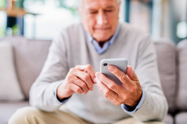 Shot of a senior man using a phone at a clinic stock photo