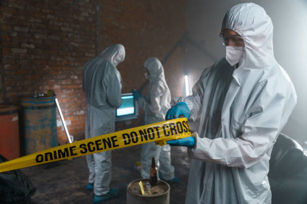 istock Criminalist unfolding the restrictive tape on a crime scene 1367835080