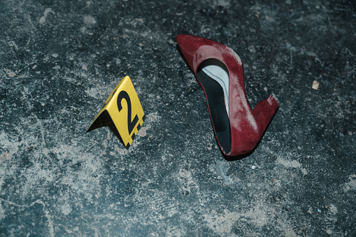 Red high heeled shoe on the floor at the crime scene from the high angle with yellow number next to it