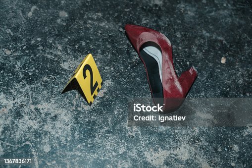 istock Red high heeled shoe on the floor at the crime scene from the high angle with yellow number next to it 1367836171