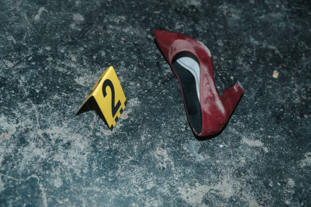 Red high heeled shoe on the floor at the crime scene from the high angle with yellow number next to it Red high heeled shoe on the floor at the crime scene from the high angle, illuminated by a flashlight killing photos stock pictures, royalty-free photos & images