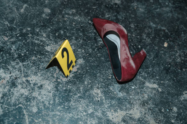 red high heeled shoe on the floor at the crime scene from the high angle with yellow number next to it - protective suit fotos imagens e fotografias de stock