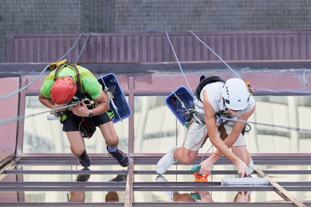 istock Industrial mountaineering worker cleaning window outside building. 1367837823