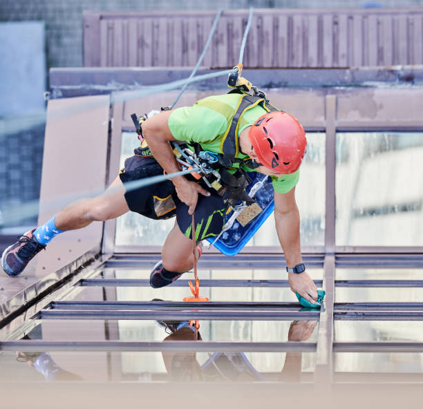 istock Industrial mountaineering worker cleaning window outside building. 1367837824