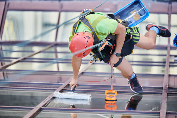istock Industrial mountaineering worker cleaning window outside building. 1367837840