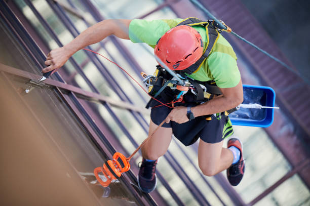 istock Industrial mountaineering worker cleaning window outside building. 1367837852