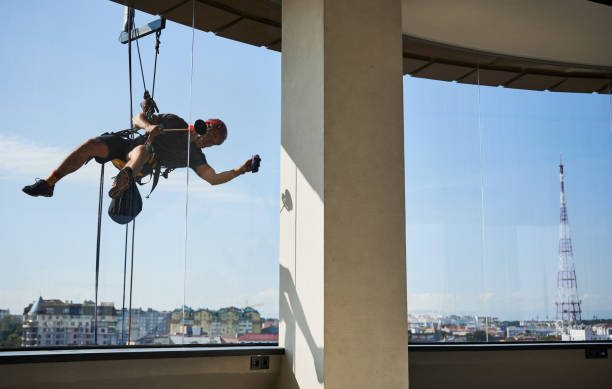 istock Industrial mountaineering worker cleaning window outside building. 1367837896