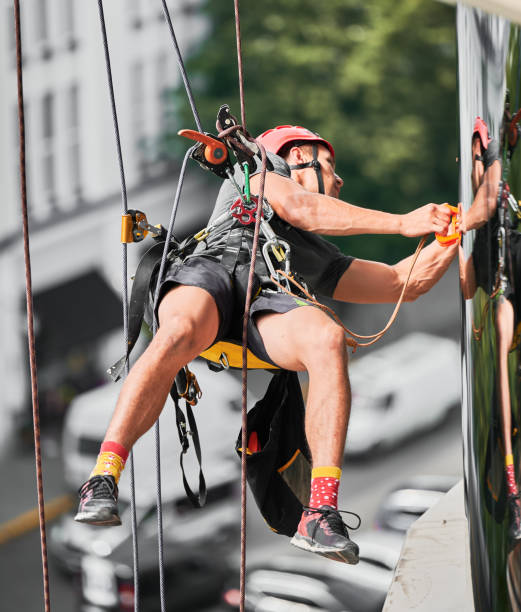 istock Industrial mountaineering worker cleaning window outside building. 1367837902