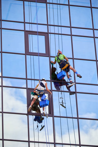 istock Industrial mountaineering worker cleaning window outside building. 1367837935