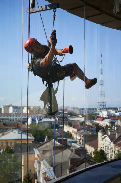 istock Industrial mountaineering worker cleaning window outside building. 1367837989
