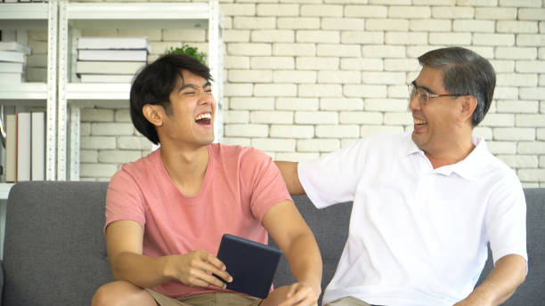 istock young grown son teaching Father Use tablet online social media At Home. 1367839720