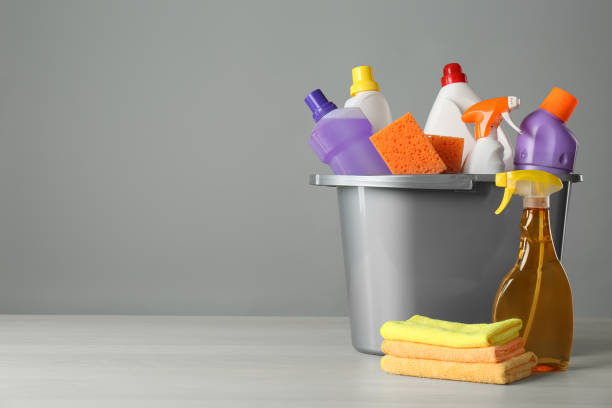 istock Bucket with cleaning products and tools on grey table. Space for text 1367841298