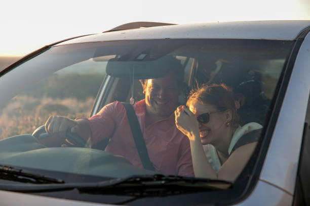 istock Young couple laughing in car. 1367841777
