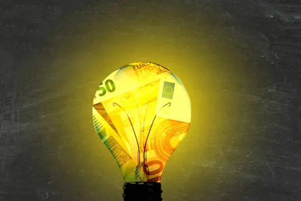 A light bulb, euro banknotes and energy costs