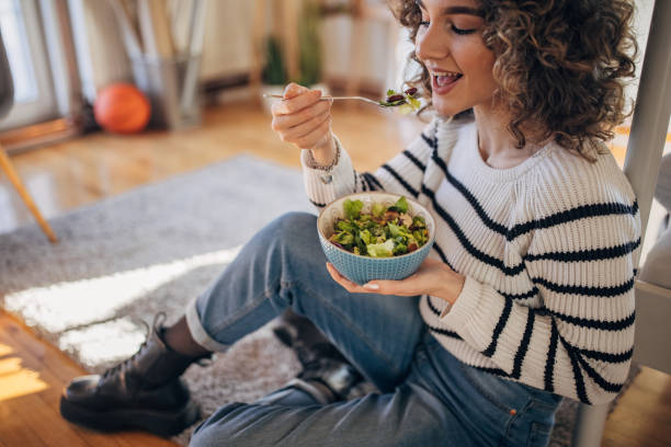 istock Young woman eating a salad 1367842874