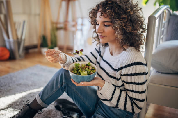 istock Young woman eating a salad 1367842883