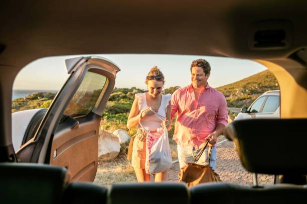 istock Young couple packing bags into car. 1367842885