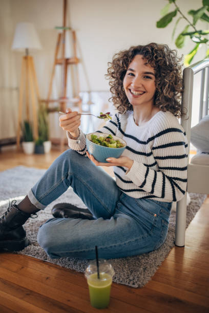 istock Young woman eating a salad 1367842896