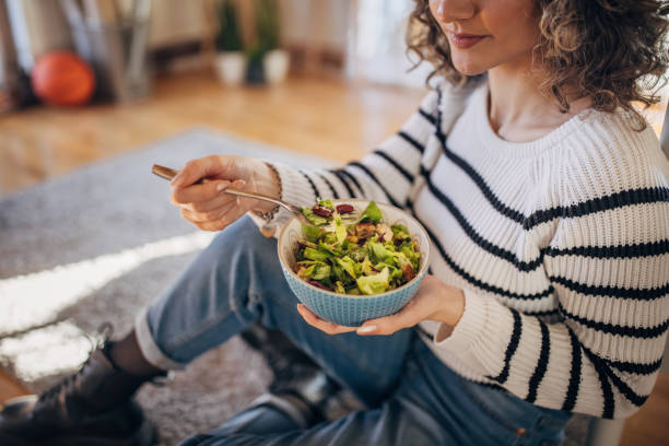 istock Young woman eating a salad 1367842912
