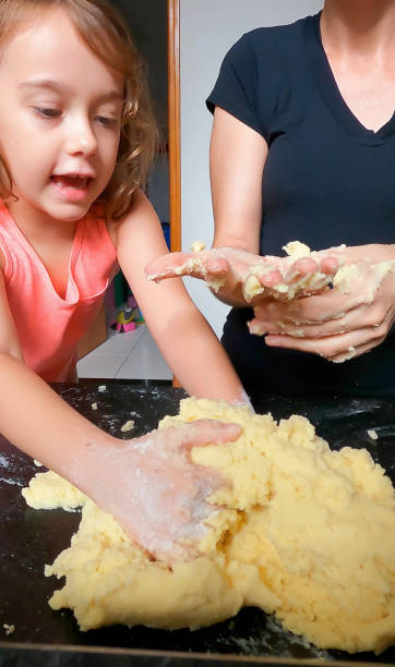 Mother and daughter cooking pasta together. stock photo