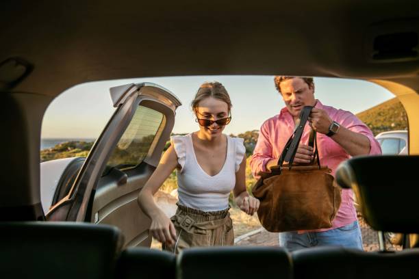 istock Young couple packing bags into car. 1367842992