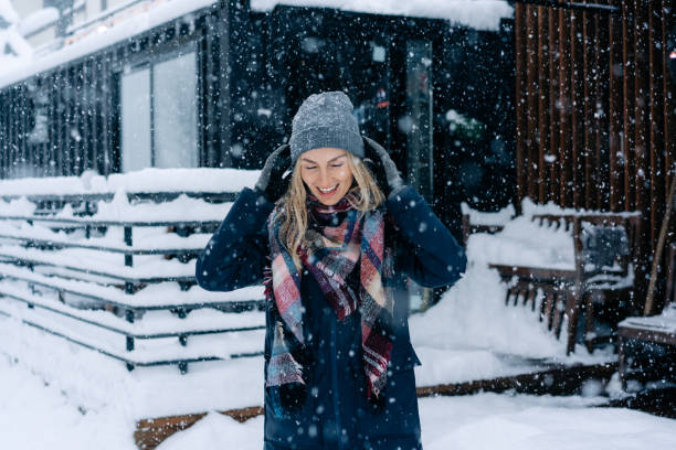 istock Happy laughing woman stands under snowfall. 1367843180