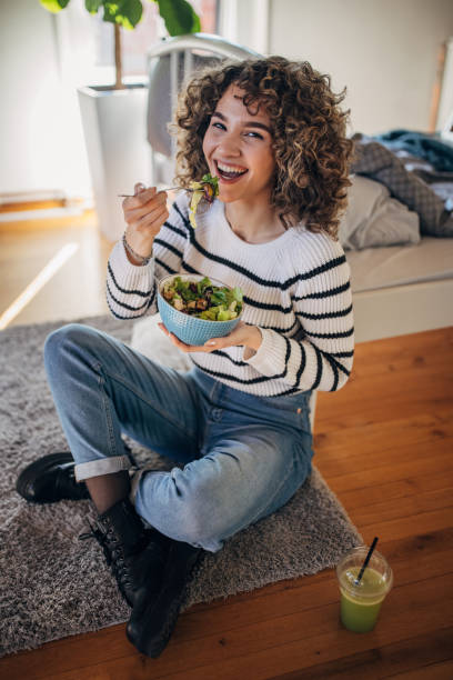 istock Young woman eating a salad 1367843247
