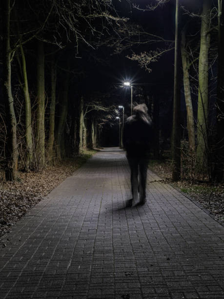 istock Person in motion walks along a uncomfortable way at night. 1367844282