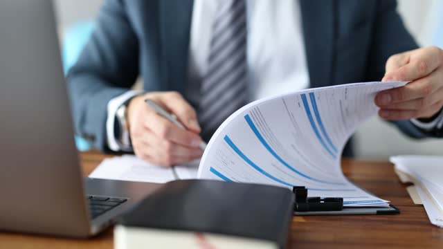 Business man studying and signing documents at table closeup 4k movie slow motion