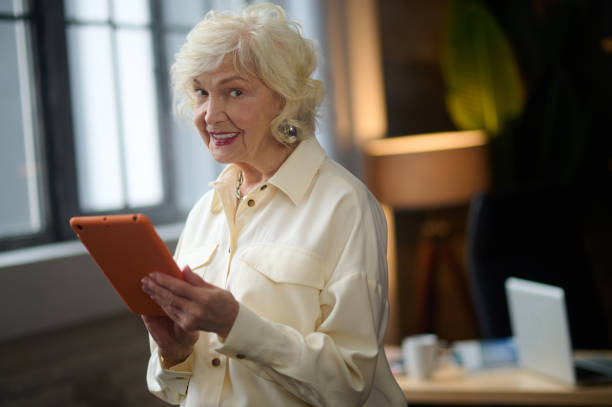 istock Woman holding tablet looking at camera 1367845587