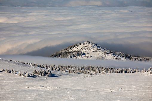 Winter mountain panorama above clouds