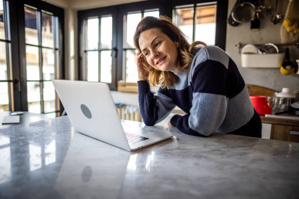 istock Woman using laptop at home 1367847078