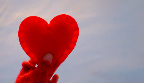 istock Red toy heart in the hand on snow background, copy space 1367847186