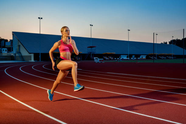 istock Runner sprinting towards success on run path running athletic track. Goal achievement concept 1367848382