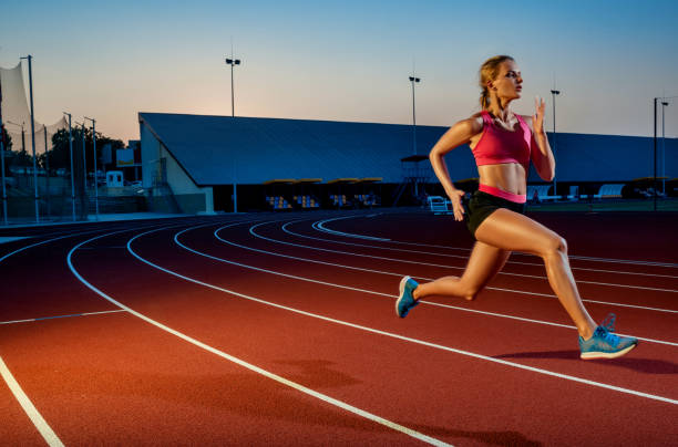 istock Runner sprinting towards success on run path running athletic track. Goal achievement concept 1367848389
