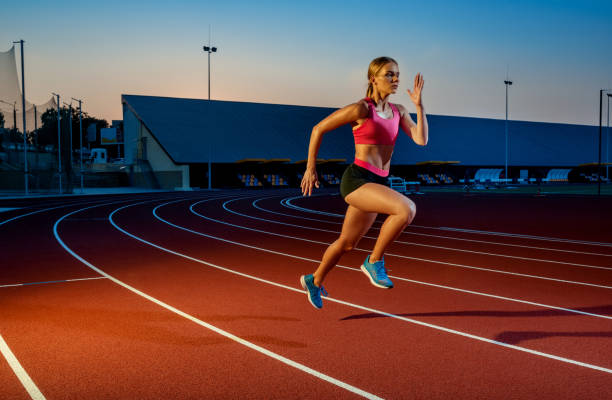 istock Runner sprinting towards success on run path running athletic track. Goal achievement concept 1367848404