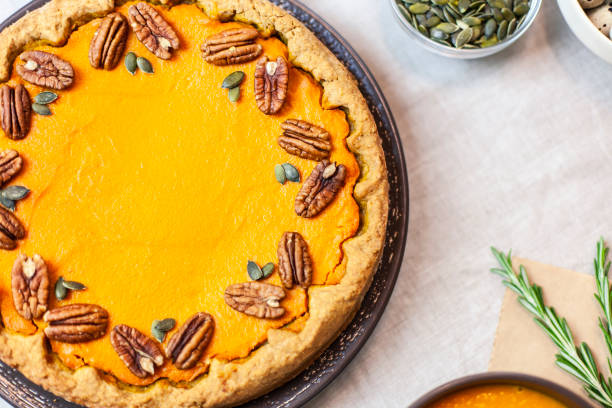 istock Pumpkin pie decorated with pecans on a served table for an autumn party food 1367848458