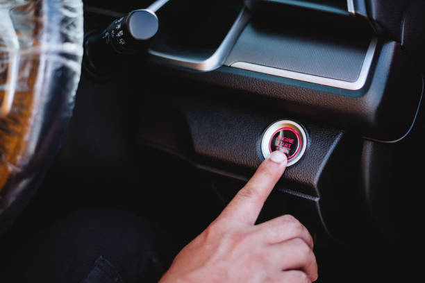 istock Close up of finger on starting the car engine using a special start and stop button built into the console in car. 1367849602