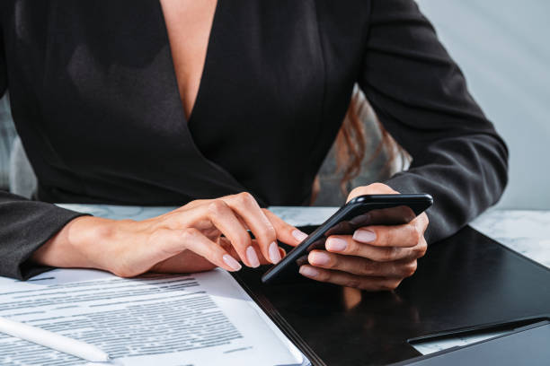 istock Woman hands typing in smartphone, finger touch screen. Light office room 1367850734